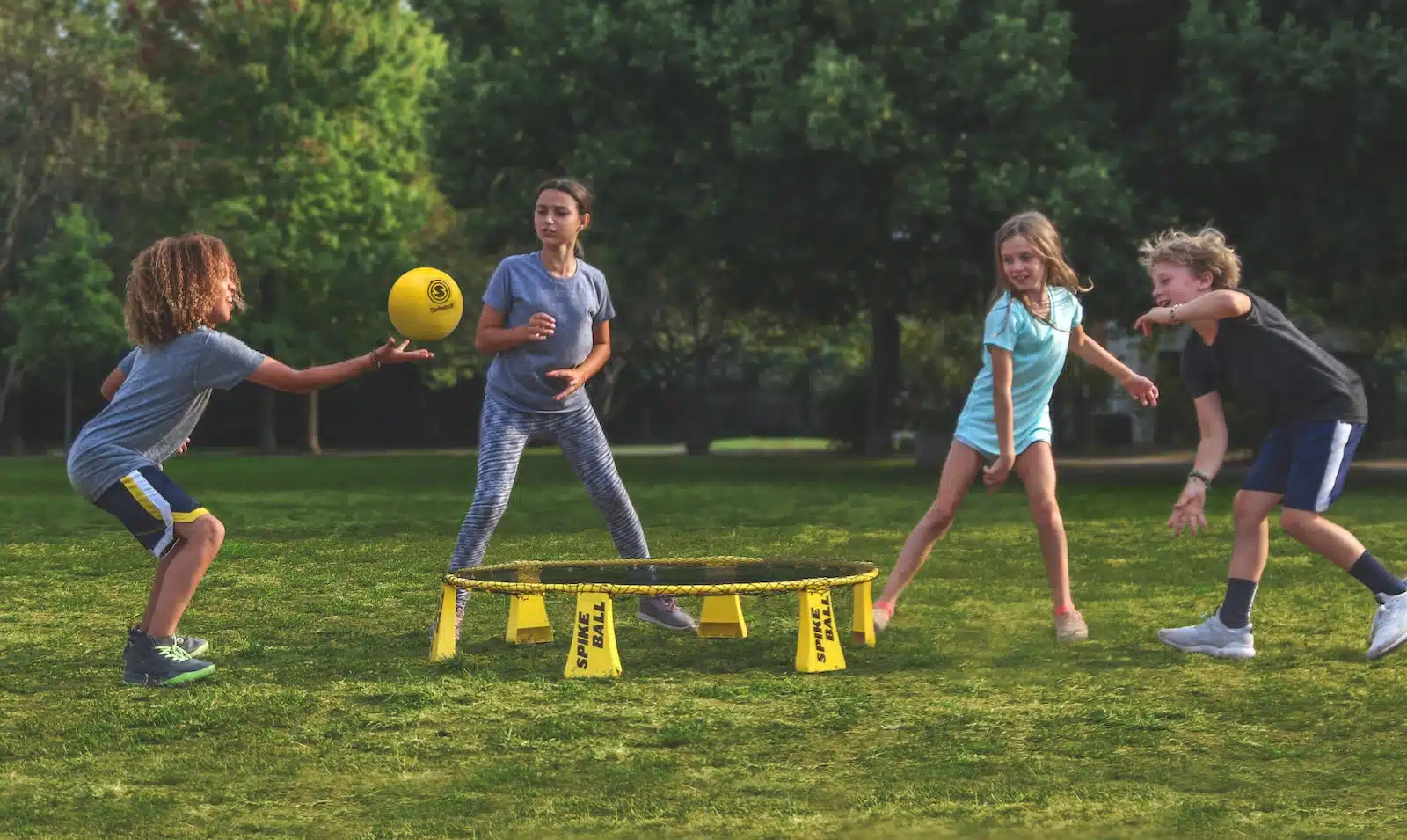 2 women playing soccer on green grass field during daytime