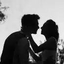 silhouette grayscale photo of man and woman attempting to kiss